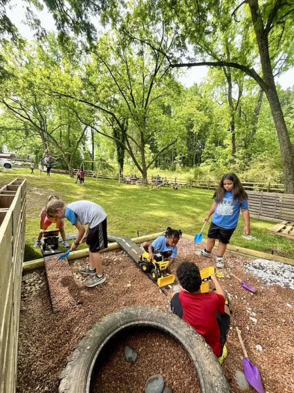 4 Children playing in a gravel put