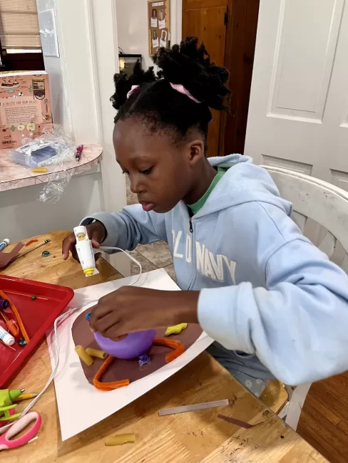 Child crafting with hot glue gun