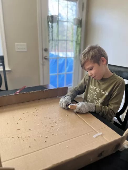 Child carving wood